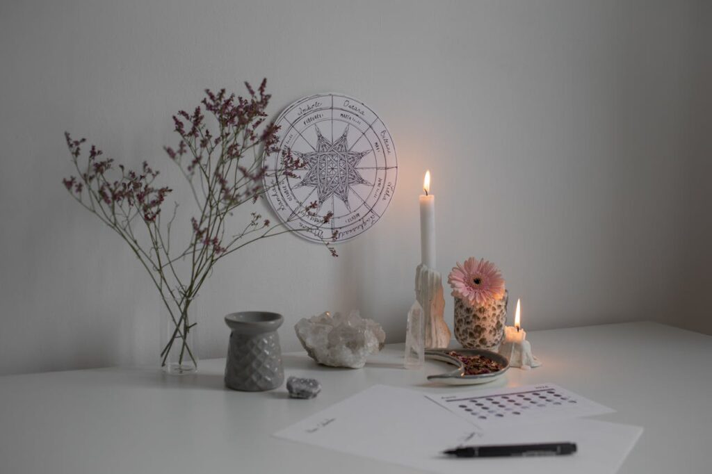 pexels-photo-20419172 A serene desk setup with candles, crystals, and a wheel of the year decoration.