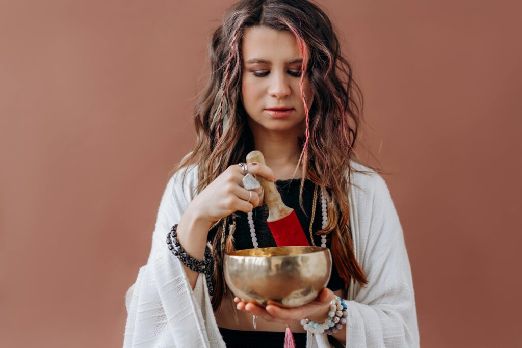 pexels-photo-6932038-6932038 A woman focuses in meditation using a Tibetan singing bowl, promoting healing and mindfulness.
